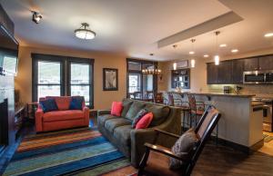 a living room with a couch and a kitchen at Spacious Village View Townhouse with Fireplace at Parry Peak Lofts townhouse in Winter Park