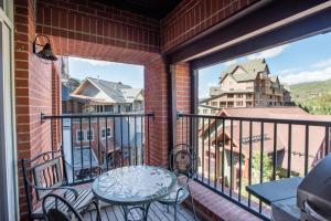 a balcony with a table and chairs and a view of a city at Spacious Village View Townhouse with Fireplace at Parry Peak Lofts townhouse in Winter Park