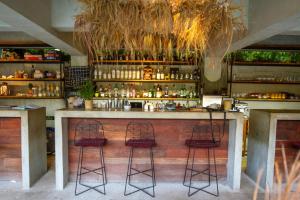 a bar with two bar stools in a room at Hotel Makaabá Eco-Boutique in Bacalar