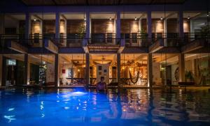 uma pessoa sentada numa piscina à noite em Hotel Makaabá Eco-Boutique em Bacalar