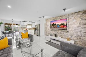 a living room with two couches and a brick wall at **MODERN 3BEDROOM W/ STUNNING BACKYARD AREA** in Fort Lauderdale