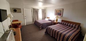 a hotel room with two beds and a television at Budget Inn Motel Gallup in Gallup +45 photos