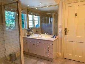 a bathroom with a sink and a mirror at Pin Oaks Luxury Bed & Breakfast in Palmerston North