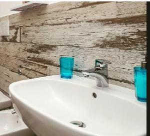 a white sink with a blue glass on top of it at CLARISSABEB in Fiumicino
