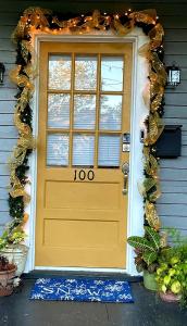 una puerta delantera amarilla de una casa con zona en The Lafayette House, en Mobile