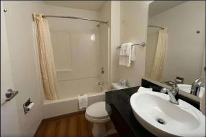 a bathroom with a sink and a toilet and a tub at Travelodge by Wyndham Madison Heights MI in Madison Heights