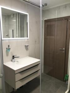 a bathroom with a sink and a mirror and a shower at Blue Sky in Skopje +42 photos