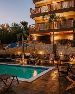 un hotel con una piscina con mesas y sombrillas en Pousada Paraíso Gaia en Praia do Rosa