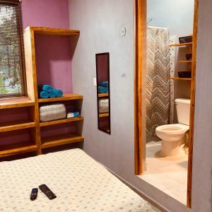 bagno con letto, servizi igienici e specchio di Almendrita Habitación I a Bacalar
