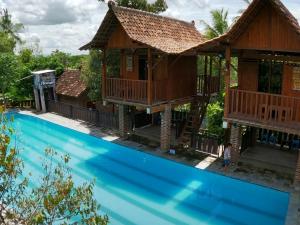 a villa with a swimming pool in front of a house at Wisma Pancoeran in Grigak