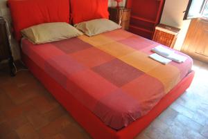 a bed with a red and orange checkered blanket at SienaHomeAndSailing 2 in Siena