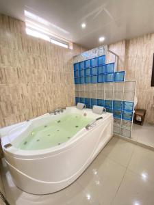 uma banheira numa casa de banho com piso verde em Hotel Los Cristales em Pereira