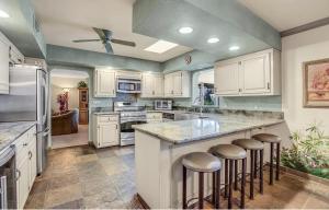 a large kitchen with white cabinets and bar stools at Dessert Hot springs / Palm Springs in Desert Hot Springs