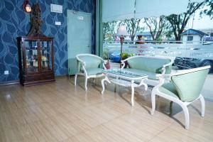 ein Wohnzimmer mit 2 Stühlen, einem Tisch und einem Sofa in der Unterkunft Dowifi Hotel -Self Service Kiosk in Sungai Petani