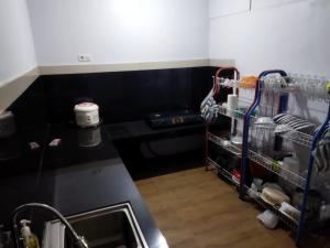 a kitchen with a sink and a black counter top at Asmanida Syariah Guest House in Bukittinggi