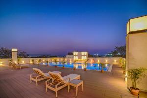 a rooftop deck with chairs and lights at night at Vivanta Jamshedpur, Golmuri in Jamshedpur