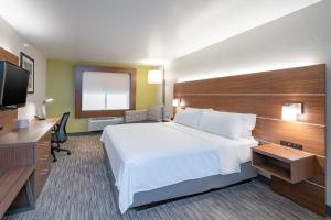a hotel room with a bed and a flat screen tv at Holiday Inn Express Hotel & Suites Elkins, an IHG Hotel in Elkins