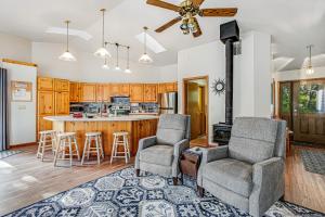 a living room with two chairs and a kitchen at Three Capes Cottage in Pacific City
