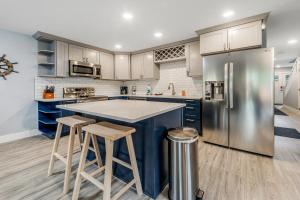 a kitchen with a large blue island and stools at SurfSide in Westport