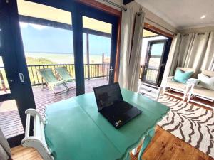 a laptop sitting on a table on a balcony at Tiptol Couple's Retreat in Jeffreys Bay
