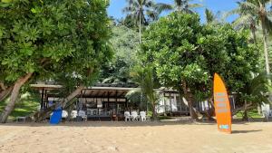 an orange sign on the beach in front of a resort at Duli Beach Resort in El Nido