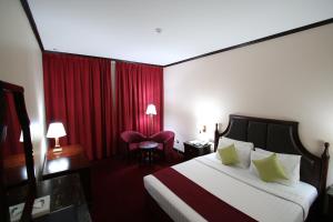 سرير أو أسرّة في غرفة في Grand Mayfair Hotel