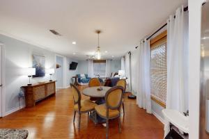 a dining room and living room with a table and chairs at Off Course in Dauphin Island