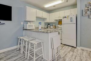 a kitchen with white appliances and white cabinets at PacMan Get Away in Myrtle Beach