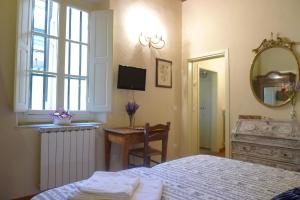 1 dormitorio con cama, escritorio y espejo en Gioberti Beccaria, en Florencia