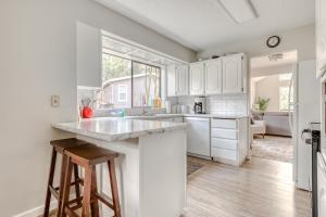 a kitchen with white cabinets and a large window at Sandy River Serenade in Rhododendron