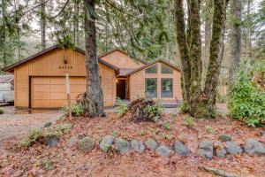 a house with a garage in the woods at Sandy River Serenade in Rhododendron