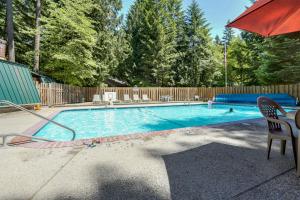 a swimming pool with a table and an umbrella at Sandy River Serenade in Rhododendron