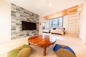 een woonkamer met een tafel en een televisie bij VILLA HAKONE STAGE in Hakone