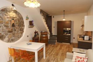 uma sala de estar com uma mesa e uma parede de pedra em Wine House (by Vacation Service) em Cefalù