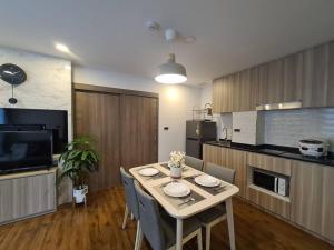 a kitchen with a table and chairs in a room at 2BR Service Condo in Sriracha in Si Racha