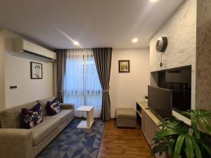 a living room with a couch and a television at 2BR Service Condo in Sriracha in Si Racha