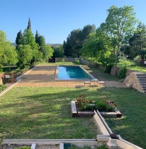 un gran patio con una piscina con flores. en CHATEAU DES SALLES, en Draguignan