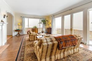 a living room with two couches and large windows at Point Radio Cottage in Gloucester