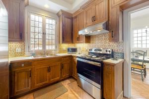 a kitchen with wooden cabinets and a stove top oven at Point Radio Cottage in Gloucester