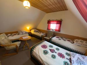 Cette chambre comprend 2 lits, une table et une fenêtre. dans l'établissement Domki Camping Harenda, à Zakopane