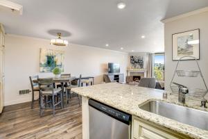 uma cozinha e sala de estar com mesa e cadeiras em Modern condo with access to pool & hot tub in great location em Oceanside