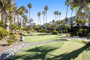 um campo de golfe em um resort com palmeiras em Modern condo with access to pool & hot tub in great location em Oceanside