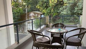 a patio with three chairs and a table on a balcony at Malsi Hill View Homestays in Dehradun