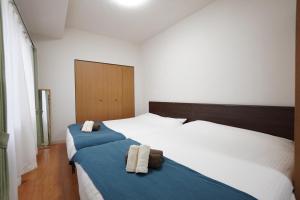 twee bedden in een hotelkamer met handdoeken erop bij 豊水すすきの駅から徒歩数分 IK Minami 6 Jo Residence 101 IK南6条レジデンス in Sapporo