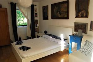 sypialnia z białym łóżkiem i krzesłem w obiekcie Rustic House Miketa - Family Summertime w mieście Lukoran