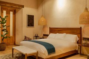 um quarto com uma cama grande e luzes pendentes em Taller de Juan - Casa Hotel em San Cristóbal de Las Casas