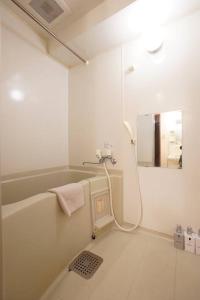 a bathroom with a bath tub and a mirror at 長期割引 豊水すすきの駅からすぐ IK Minami 6 Jo Residence 803 IK南6条レジデンス in Sapporo +34 photos