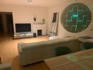 uma sala de estar com um sofá e uma televisão de ecrã plano em nice and cosy apartment em Edegem