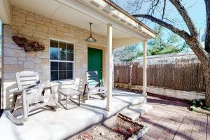 a patio with chairs and a table and a fence at Sip & Stay in Fredericksburg