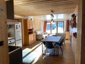 a kitchen and dining room with a table and chairs at Chalet Cyclamens- 65m2 plein centre des Carroz - WIFI & parking! in Les Carroz d'Araches
